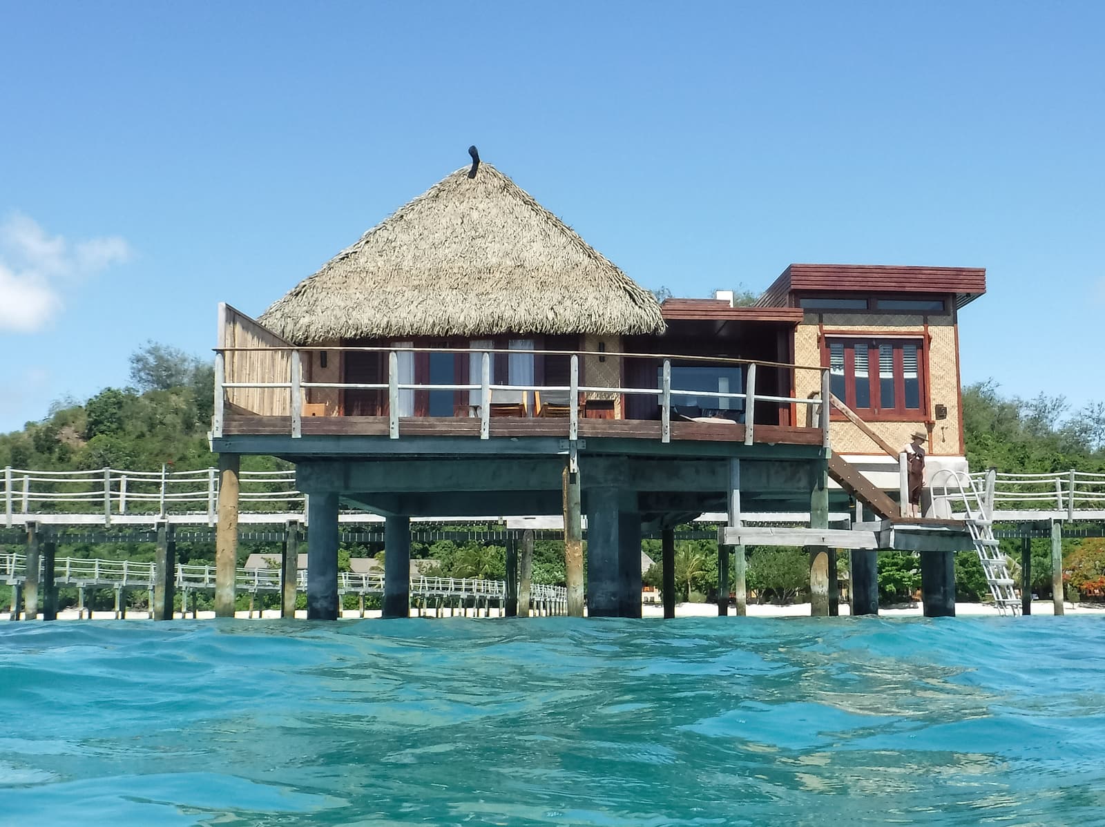 An overwater building on stilts above the clear lagoon at Likuliku on Malolo Island