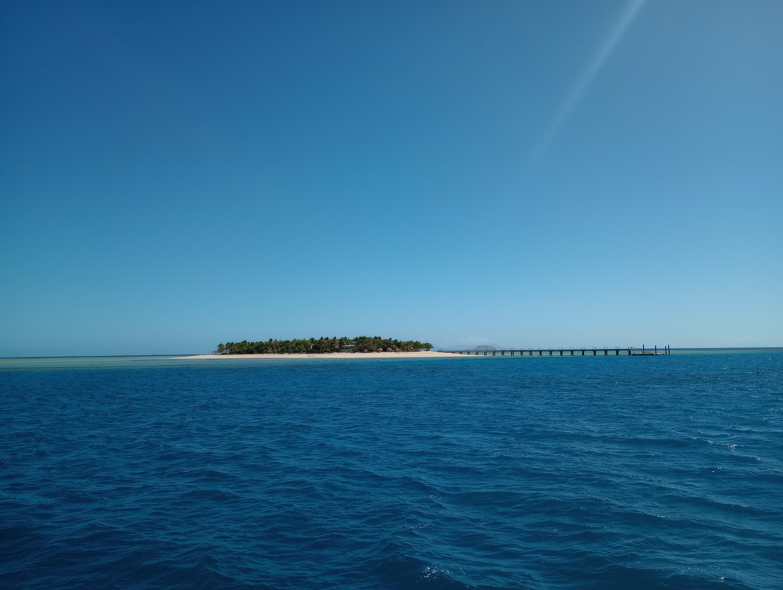 Tivua Island, a coral cay with a long jetty, seen from the sea