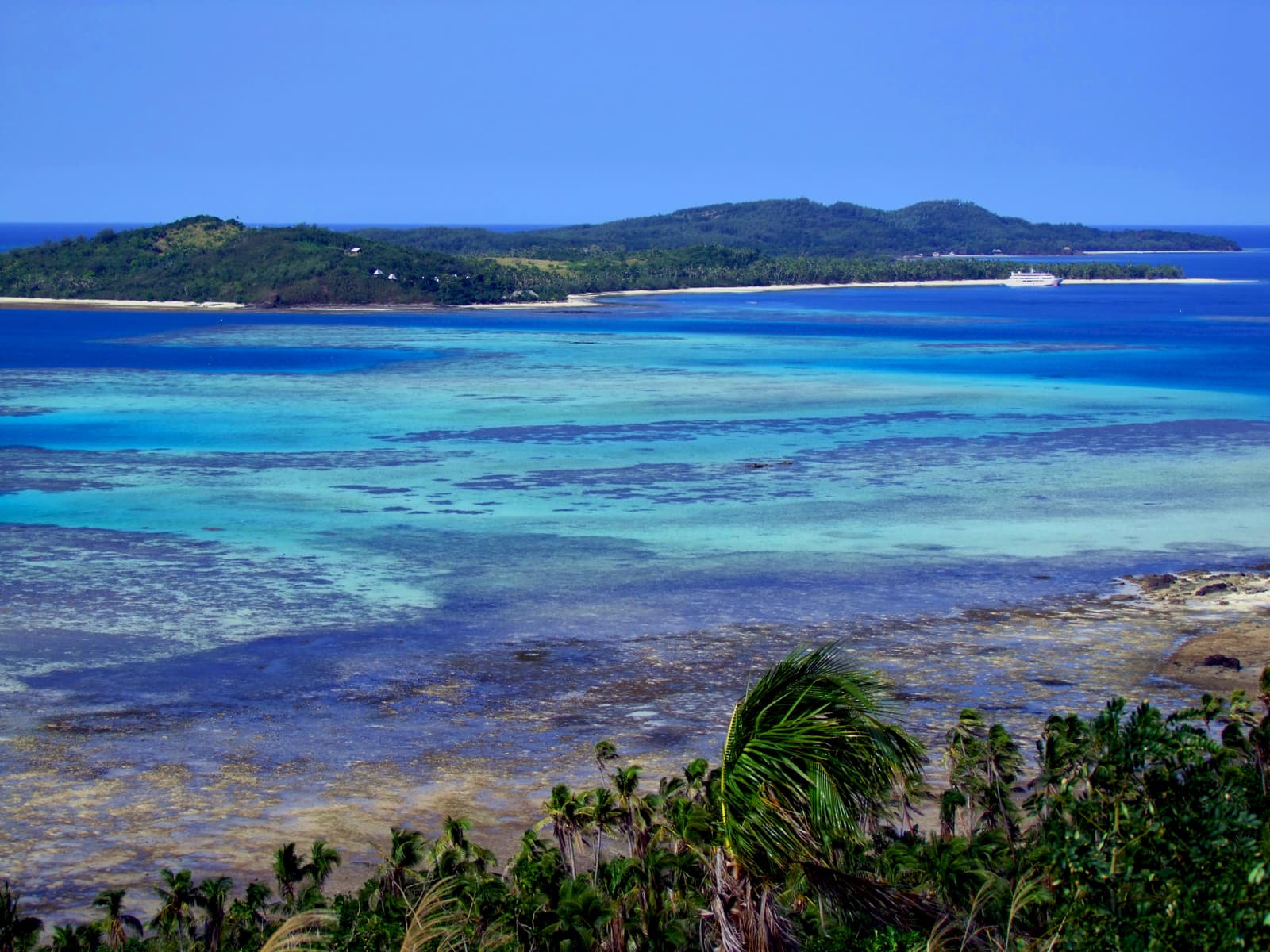 View over a turquoise channel between two hilly islands in the Yasawa group