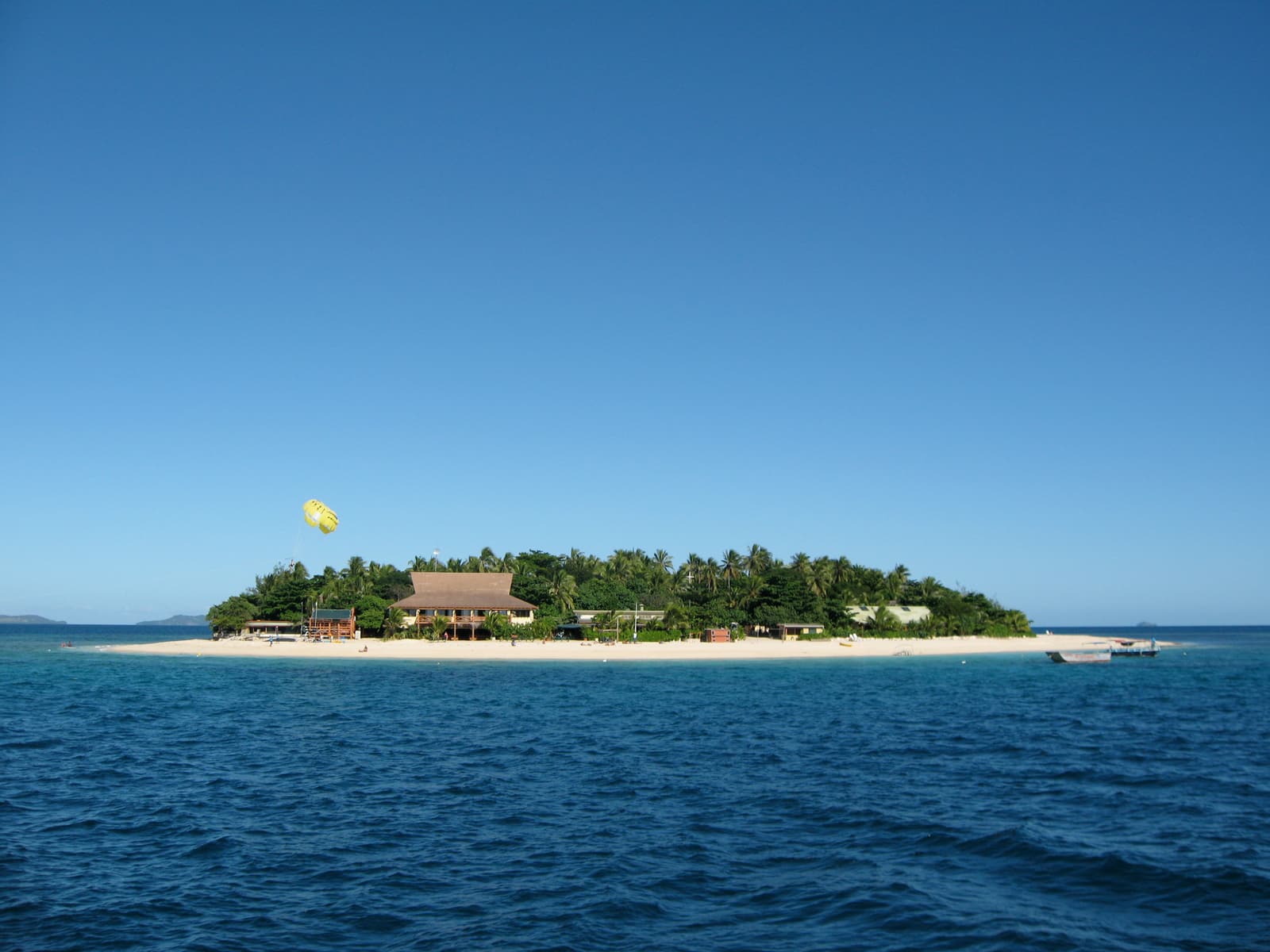 Beachcomber Island, a small coral cay ringed by white sand, seen from the water